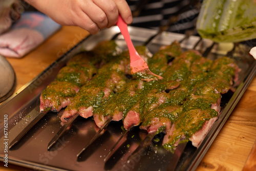 The chef greases the prepared fish fillet with green sauce