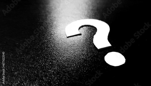 Question mark design made of paper on dark background photo