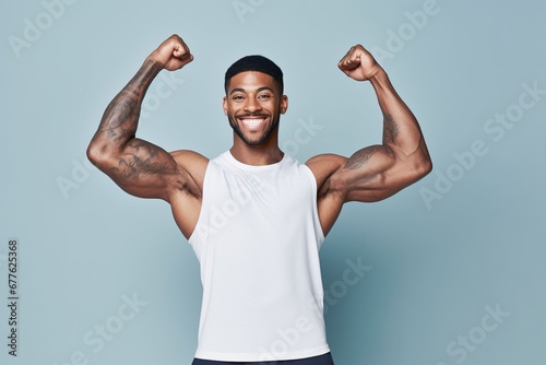 young man with tattoo flexes his bicep, studio shoot