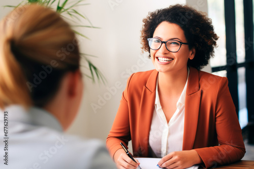 Happy hiring manager interviewing a job candidate in her office photo