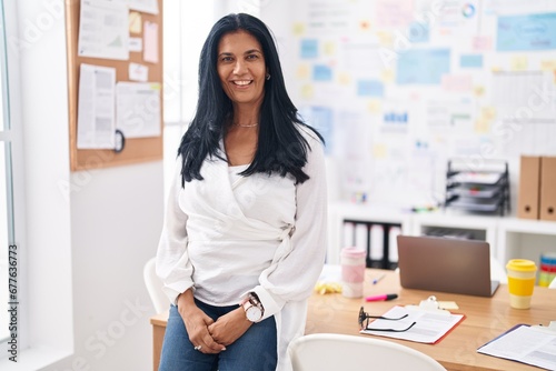 Middle age hispanic woman business worker smiling confident at office