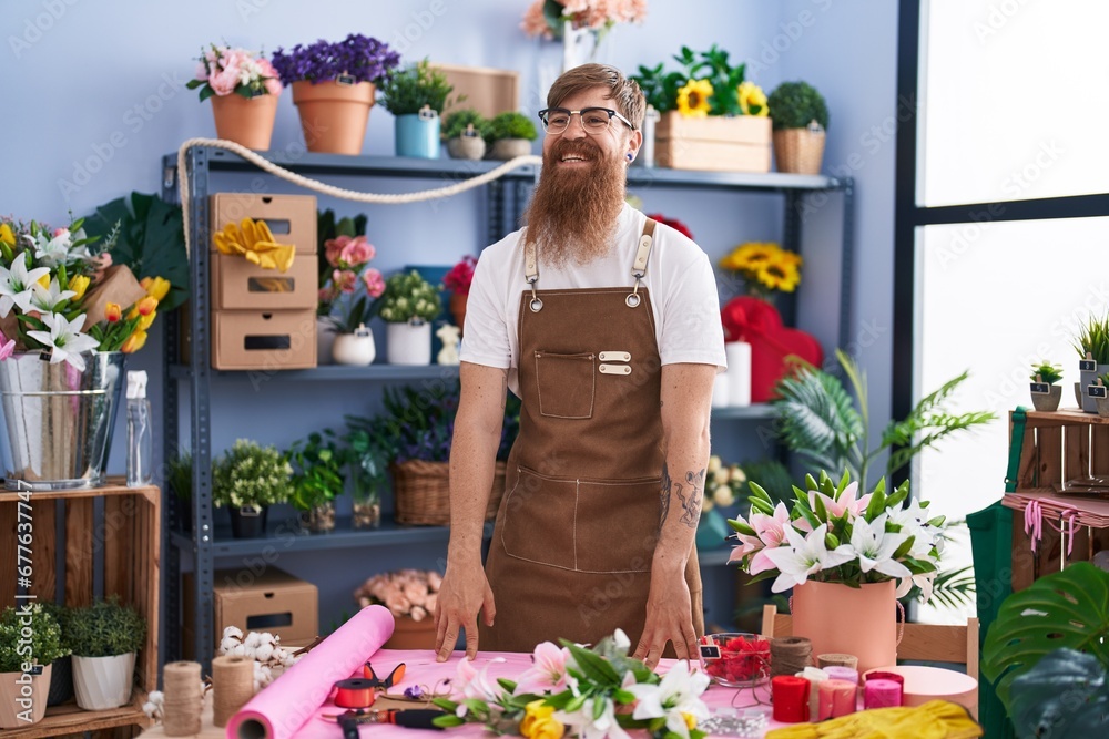Young redhead man florist smiling confident standing at flower shop