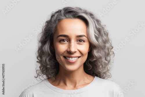 Middle age adult woman studio portrait. Beautiful mature woman with gray hair smiling happy over grey background. Generative AI