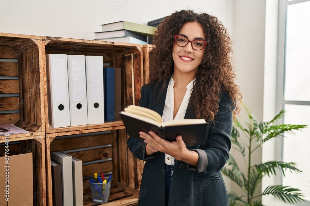 Young beautiful hispanic woman business worker smiling confident reading book at office Young beautiful hispanic woman business worker smiling confident reading book at office