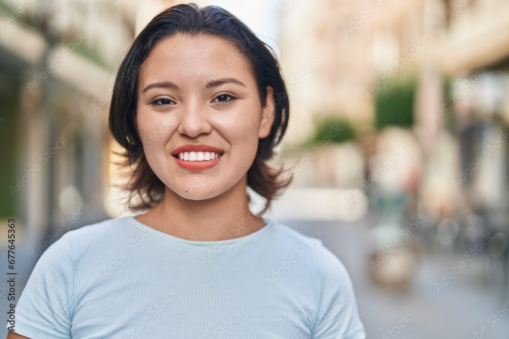 Young hispanic woman smiling confident standing at street