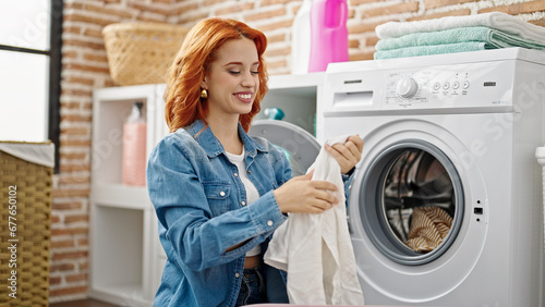 Young redhead woman smiling confident washing clothes at laundry room