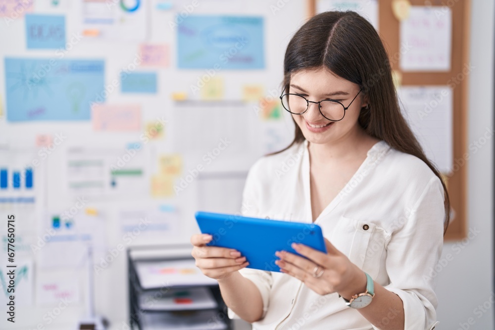 Young caucasian woman business worker smiling confident using touchpad at office Young caucasian woman business worker smiling confident using touchpad at office