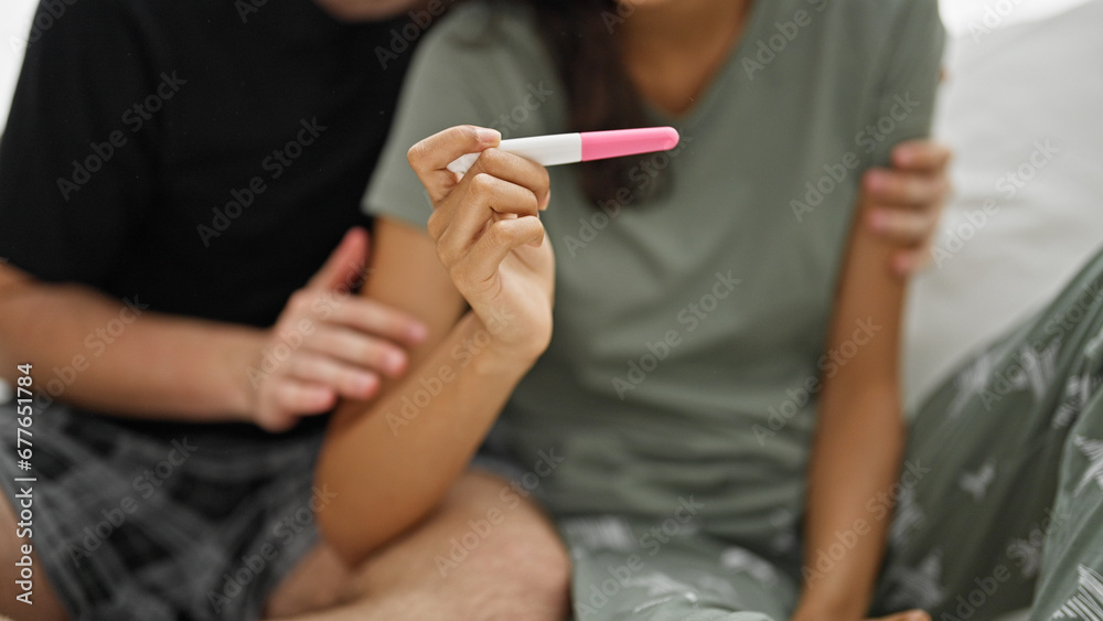 Expecting couple's heart-warming morning hug in bedroom confirming pregnancy test result!
