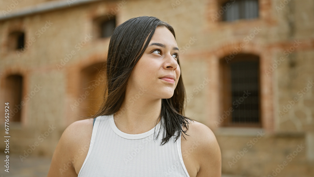 Young beautiful hispanic woman looking to the side with serious expression at street