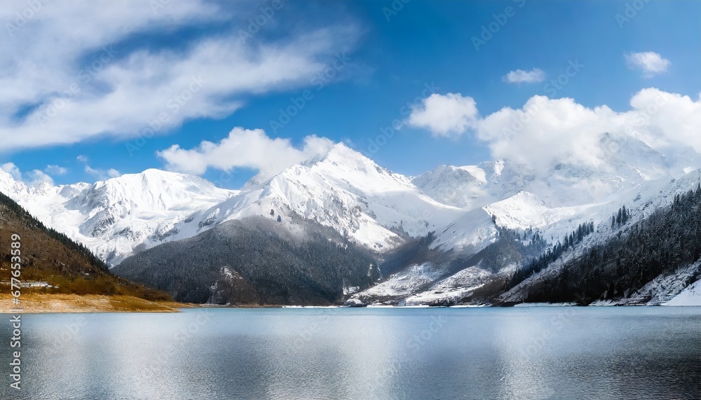 Awesome mountain winter landscape with snow capped mountains with blue lake in front. Nature and travel concept