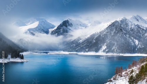 Awesome mountain winter landscape with snow capped mountains with blue lake in front with clear blue sky. Nature and travel concept