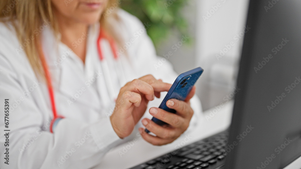 Middle age hispanic woman doctor using computer and smartphone at the clinic Middle age hispanic woman doctor using computer and smartphone at the clinic