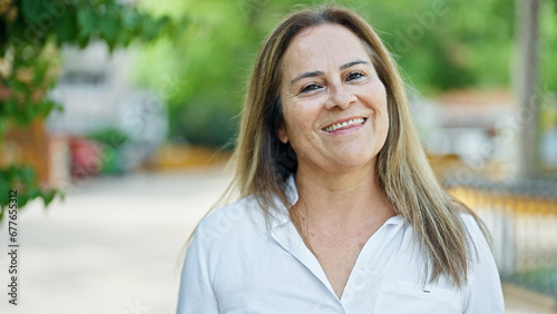 Middle age hispanic woman smiling confident standing at park © Krakenimages.com