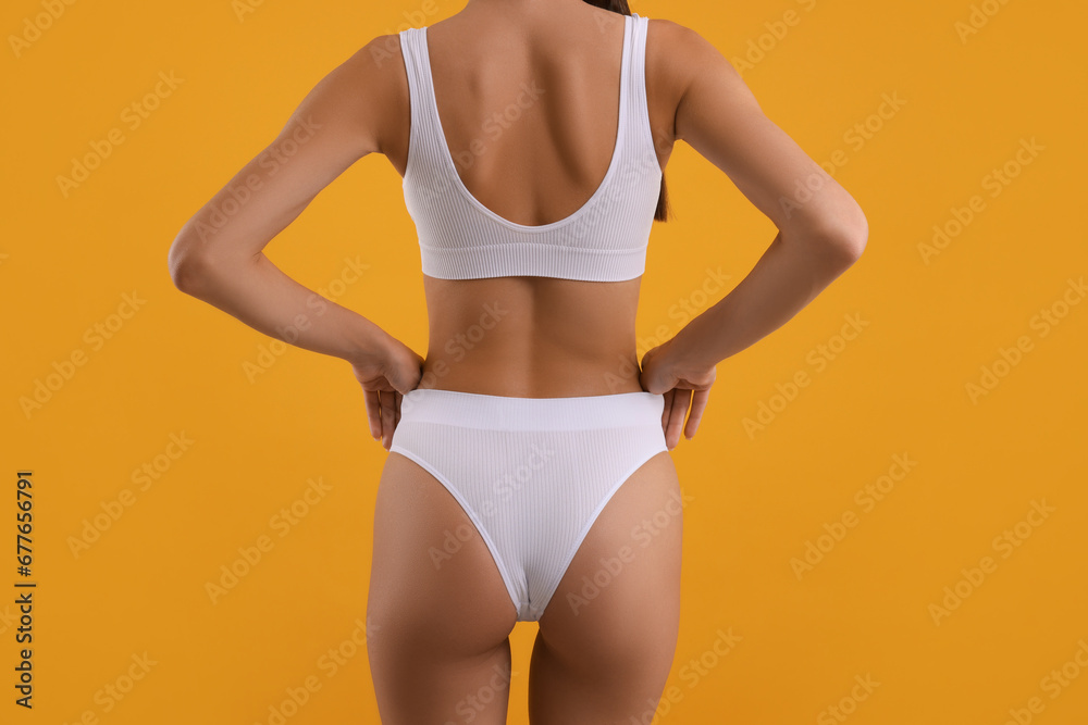 Naklejka premium Young woman in stylish white bikini on orange background, closeup