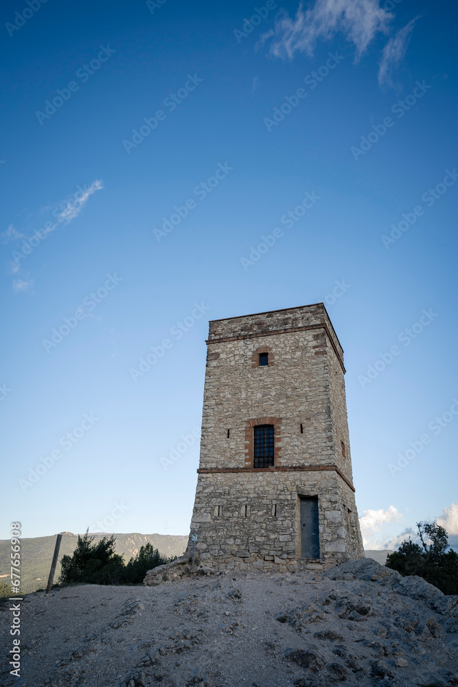 Ancient Stone Telegraph Tower in the Shadows and Stone Path at Puigracios, Catalonia