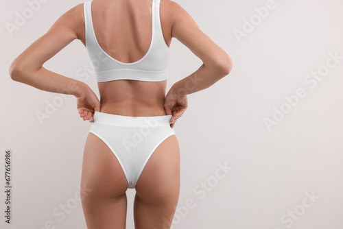 Young woman in stylish bikini on white background, closeup. Space for text