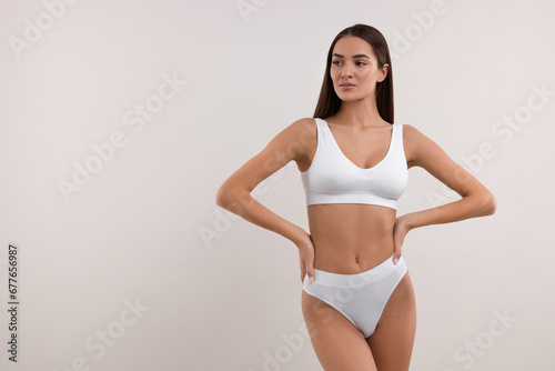 Young woman in stylish bikini on white background. Space for text