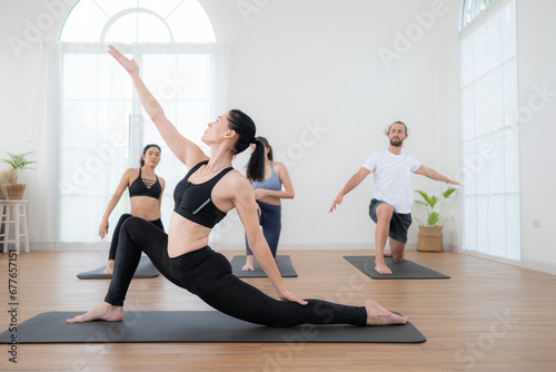 Group of people practicing yoga in a studio. Yoga class concept.