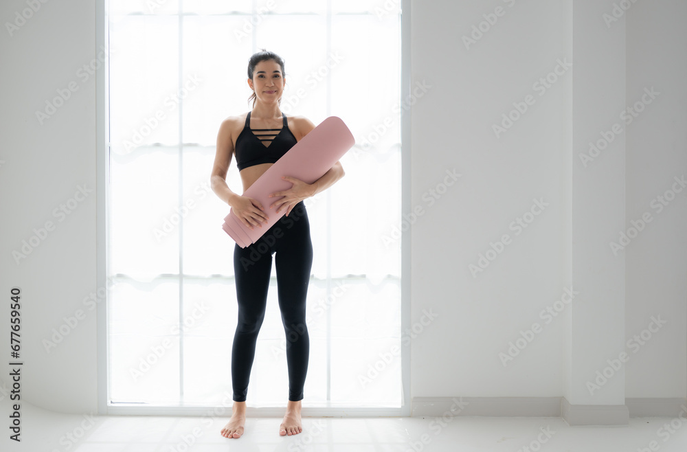 Full length portrait of a young woman holding yoga mat isolated on white background Full length portrait of a young woman holding yoga mat isolated on white background