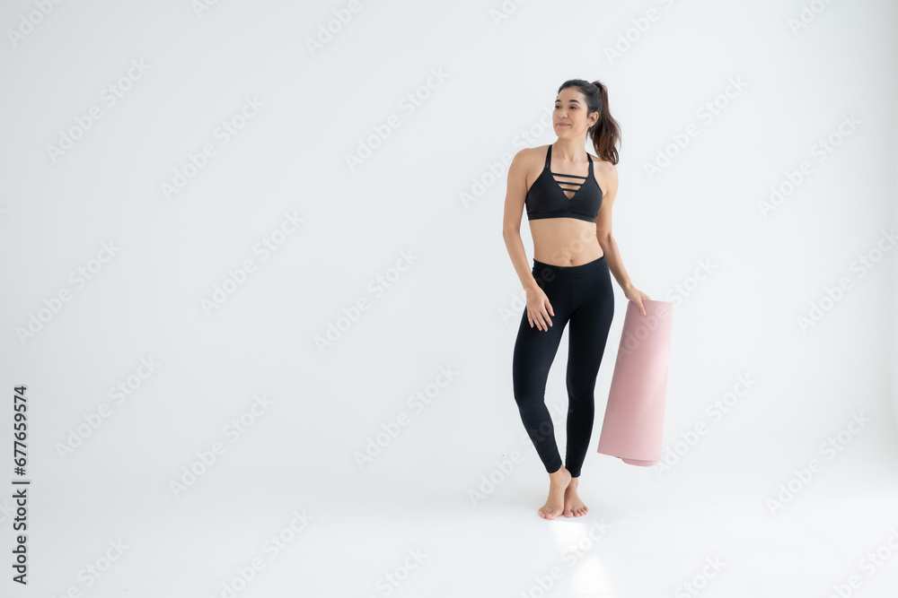 Full length portrait of a young woman holding yoga mat isolated on white background