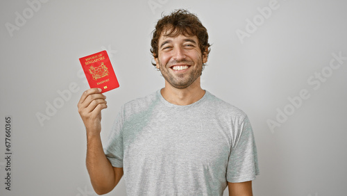 Beaming young man joyfully presents his pass, a singapore passport, confidently standing isolated on a white background