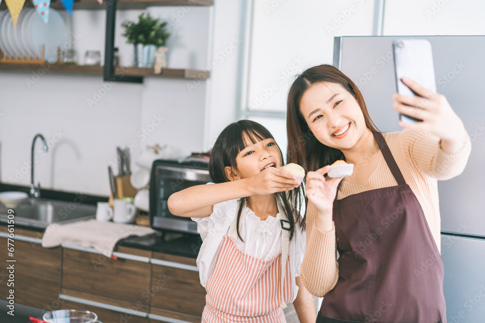 Happy asian family mother and daughter cooking in kitchen selfie with smartphone for social media Happy asian family mother and daughter cooking in kitchen selfie with smartphone for social media