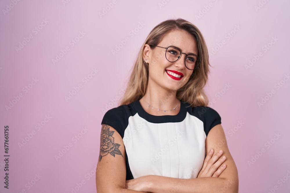 Young beautiful hispanic woman business worker smiling confident standing with arms crossed gesture over isolated pink background