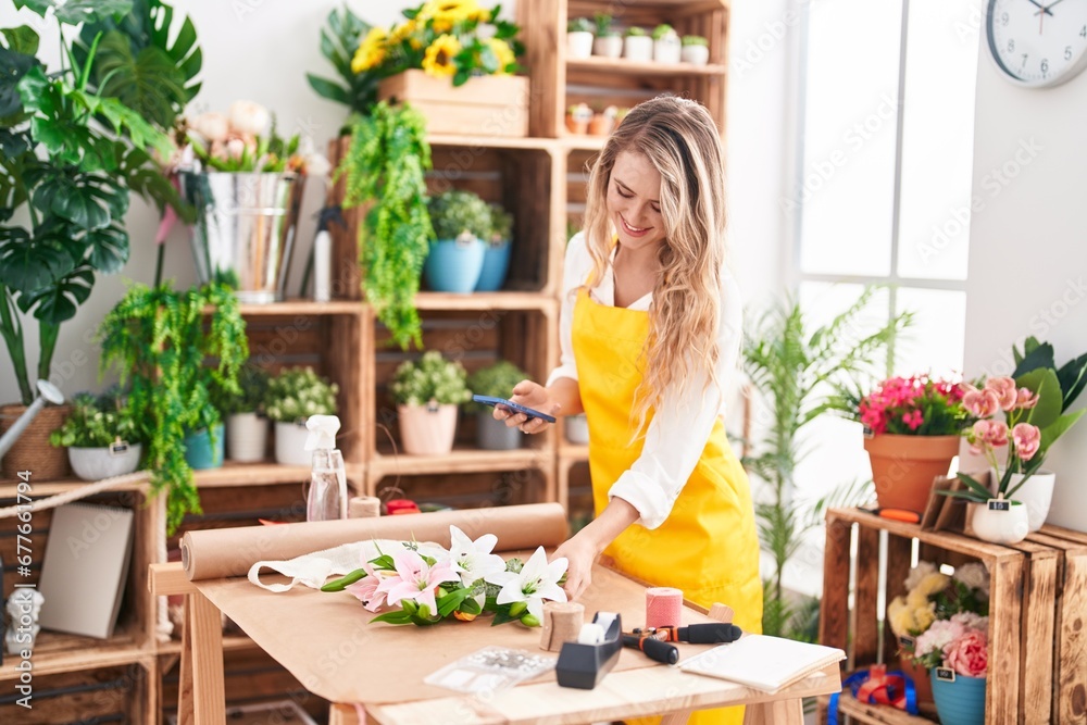 Young blonde woman florist make photo to flowers by smartphone at florist