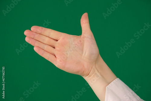 a raised five fingers, hand symbol, viewed from front isolated on green background. High quality photo photo