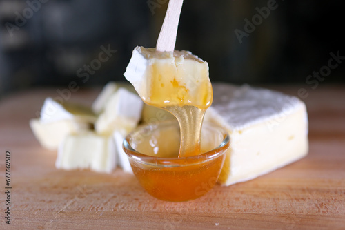 Composition of Italian cheese, on a wooden cutting board. One hand takes the knife and breaks a couple of pieces to savor the quality. High quality 4k footage photo