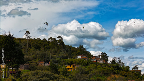Foto en San Felix, Bello, Colombia. Se aprecia en la foto a personas disfrutando del vuelo en parapente, en un lugar con paisajes extraordinarios.