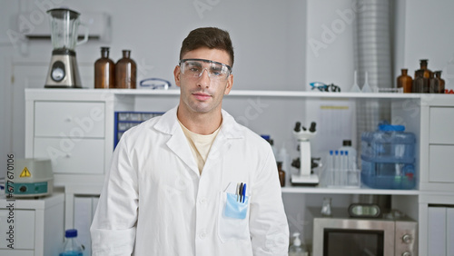 A young  hard-working hispanic scientist with a serious expression stands in the cozy laboratory  engrossed in medical research.