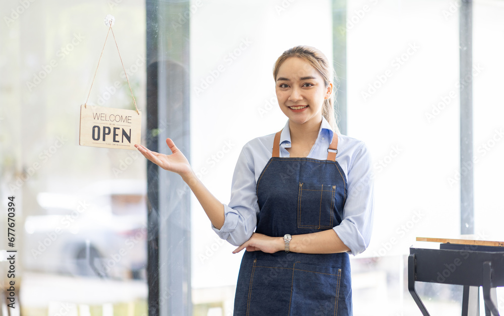 Happy SME business barista cafe owner Asian woman waitress apron and staning at the door with a sign Open waiting for customers , cafes and restaurants entrepreneur Small business concept. Happy SME business barista cafe owner Asian woman waitress apron and staning at the door with a sign Open waiting for customers , cafes and restaurants entrepreneur Small business concept.