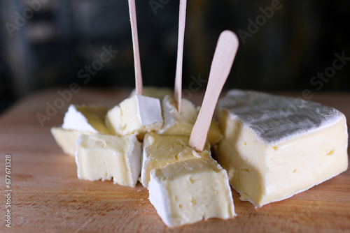 Composition of Italian cheese, on a wooden cutting board. One hand takes the knife and breaks a couple of pieces to savor the quality. High quality 4k footage photo