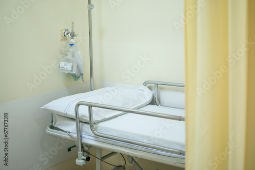 Hospital bed or stretcher with light yellow curtain and purified oxygen behind © CarlosMSubirats