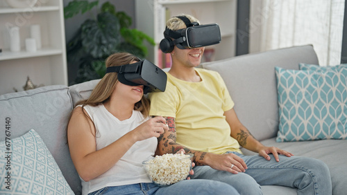 Foto Beautiful couple watching movie on virtual reality glasses at home