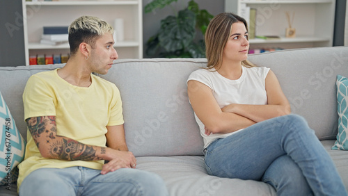 Beautiful couple sitting on sofa with problems at home