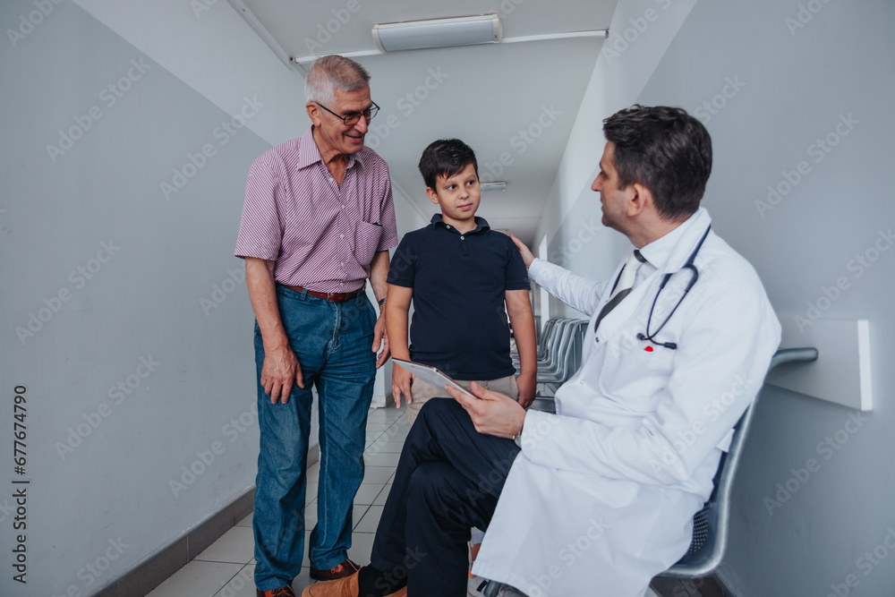 Doctor advising child, discussing health problems, examining medical results, providing successful solutions. Grandfather present for support.