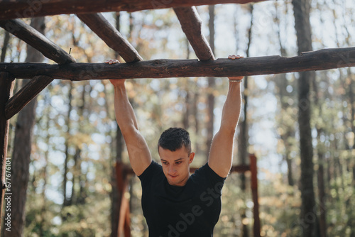 A happy hiker enjoys a sunny day doing pull ups outdoors in a mountain forest.