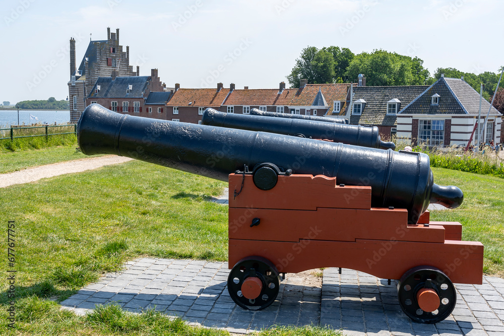 Three old cannons on top of the city wall in front of the marina of Veere, Zeeland