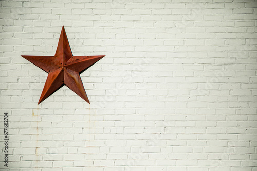 Red star on white brick wall 
 photo