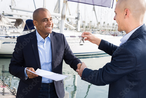 Two men in suits buy and sell a yacht in the seaport © caftor