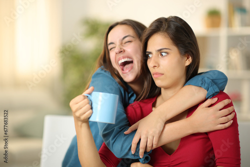 Excited woman embracing a perplexed friend photo