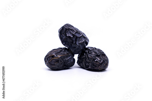Creative layout made of three Ajwa dates fruits isolated on a white background. Ramadan Arabic food concept. Ajwa is a palm date that is widely grown in Medina and is good for health.