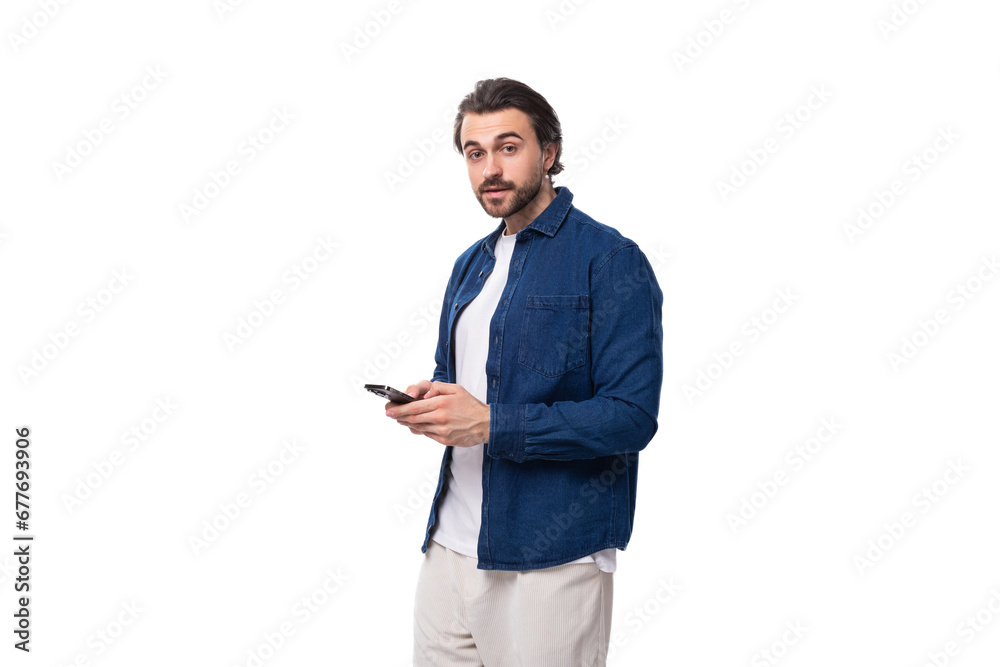young handsome brunet european guy in a casual blue shirt on a white background