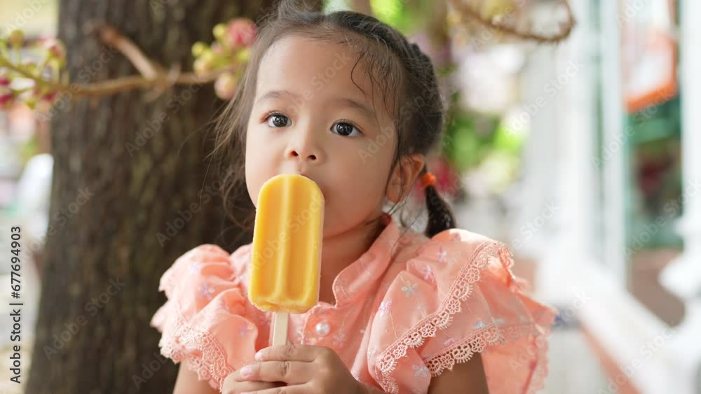 Little asian Thai girl enjoying eat ice cream wear raditional Thai suit in buddhist temple outdoor summer vacation Little asian Thai girl enjoying eat ice cream wear raditional Thai suit in buddhist temple outdoor summer vacation