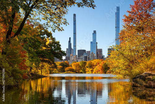 Central Park in autumn by the Lake with view of Billionaires' Row skyscrapers. Manhattan, New York City