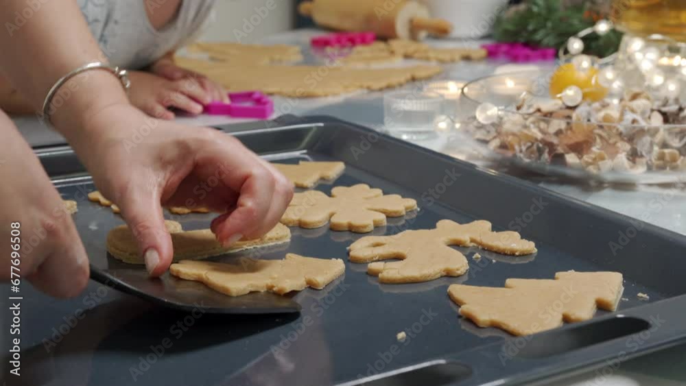 mother and child cooking together pastries, woman and little boy putting cookie cutter on rolled dough to bake Christmas gingerbread cookies mother and child cooking together pastries, woman and little boy putting cookie cutter on rolled dough to bake Christmas gingerbread cookies