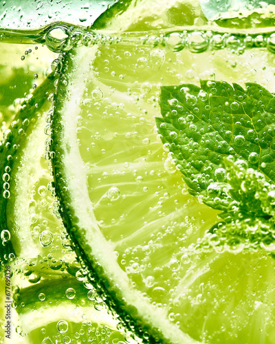 Close up of a glass filled with lime in sparkling water and mint