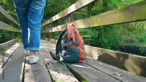 Orange backpack  on old bridge against waterfall . Travel concept. photo